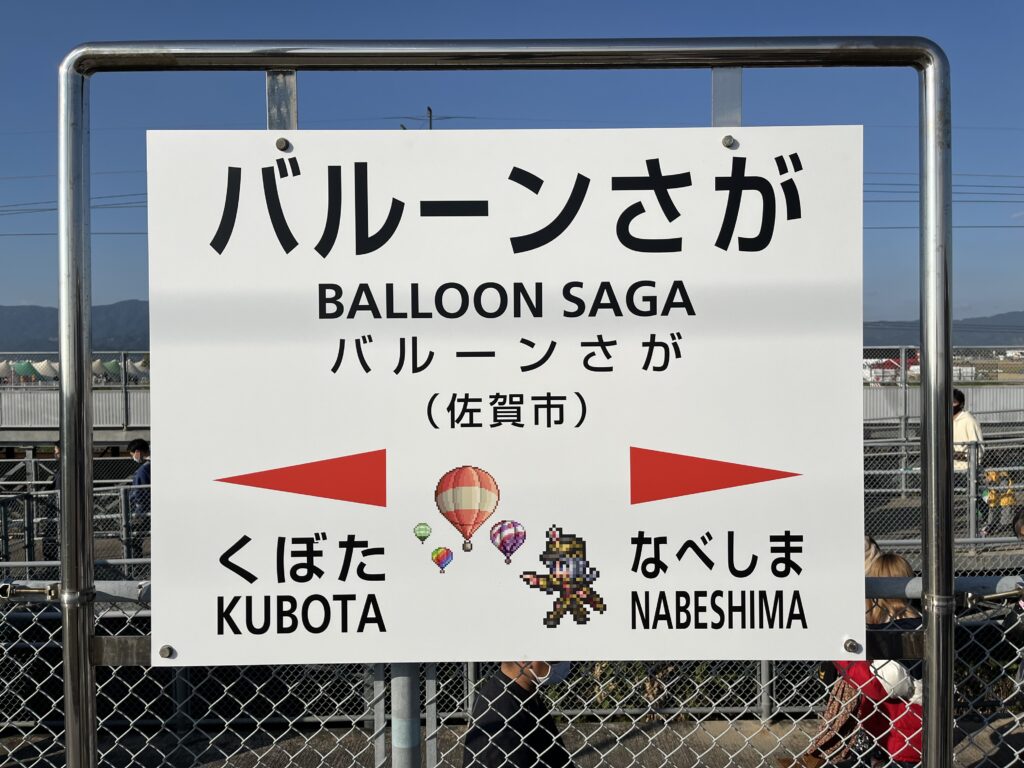 The station sign for Balloon Saga Station, featuring pixel art images of hot air balloons